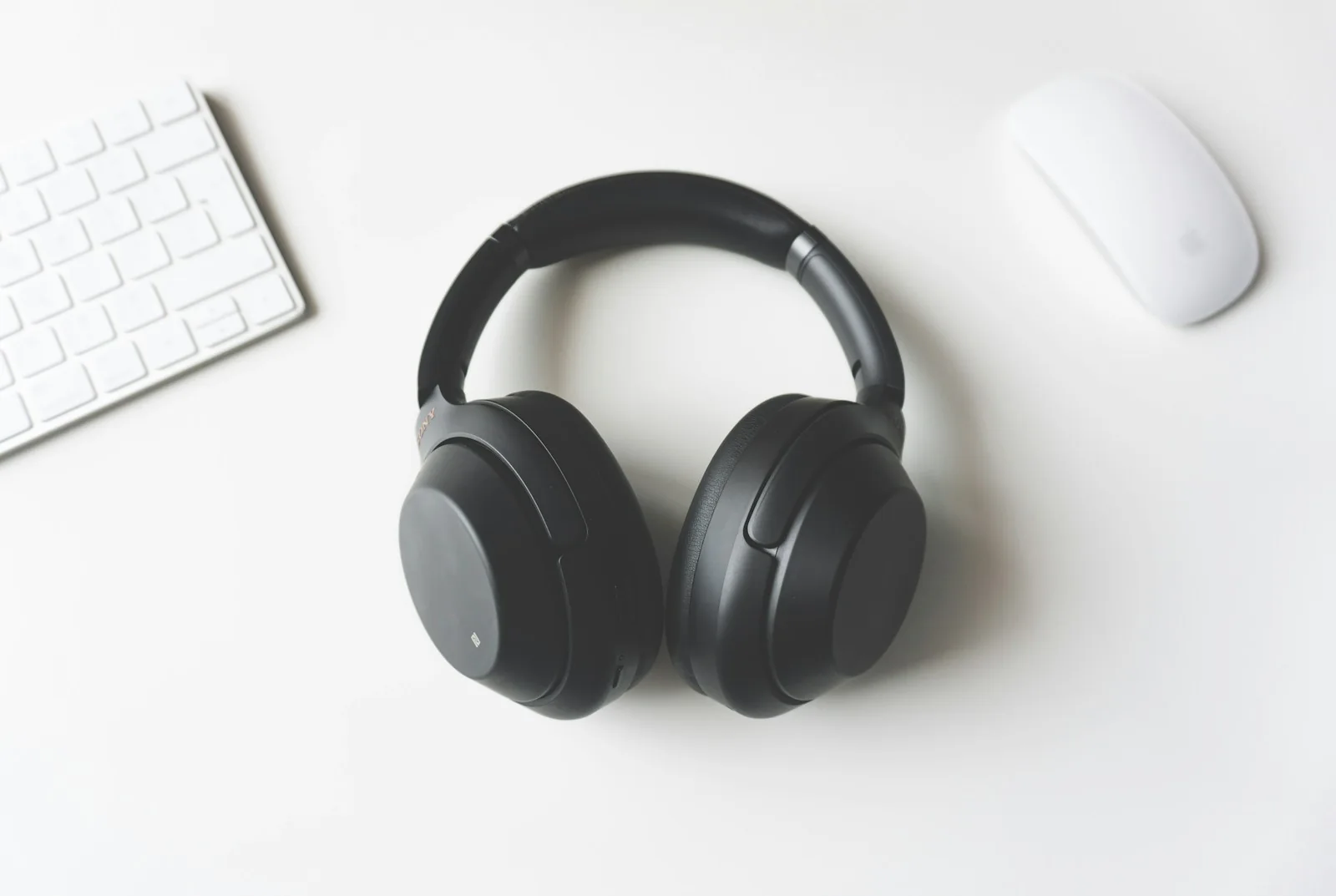 Black over-ear headphones on a clean white desktop