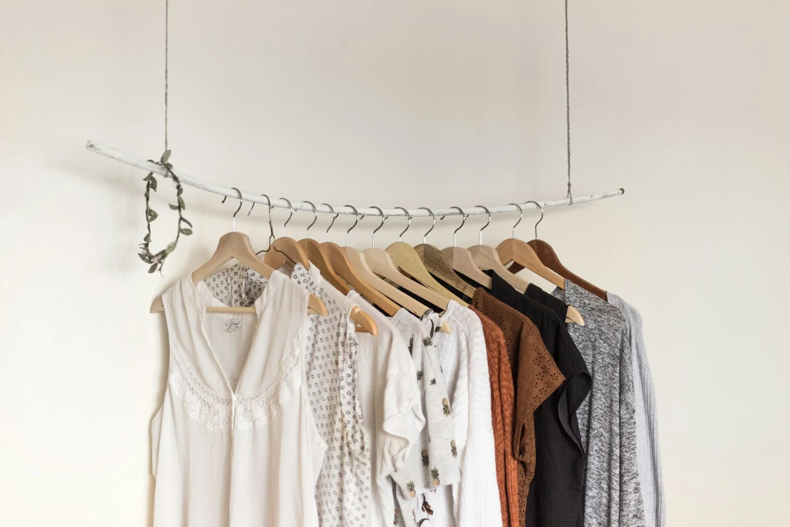 A neutral collection of cotton and linen garments on an open clothes rail